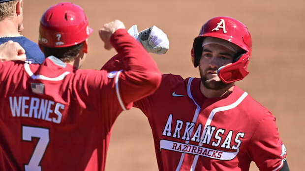 Razorbacks' John Bolton celebrates with Bobby Wernes after reaching first base against Auburn on Saturday.
